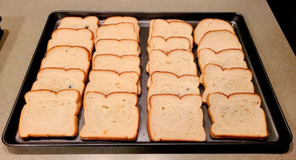pieces of bread laid out on a cooking sheet.
