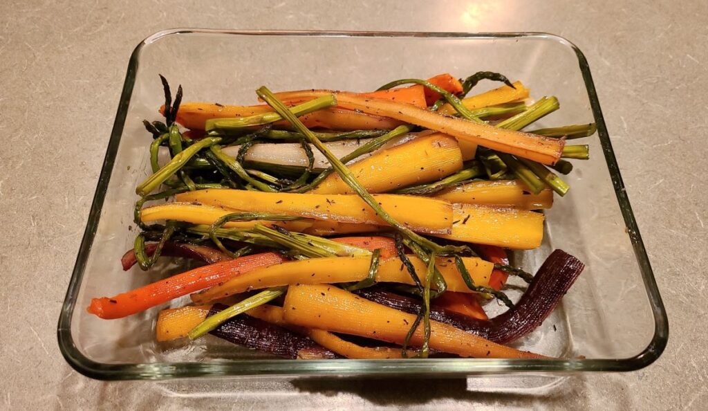 easy roasted carrots and asparagus recipe with maple glaze in a glass storage container