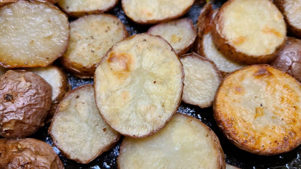 Circles of  Easy Oven Roasted Potatoes With Rosemary Butter in a cast iron.