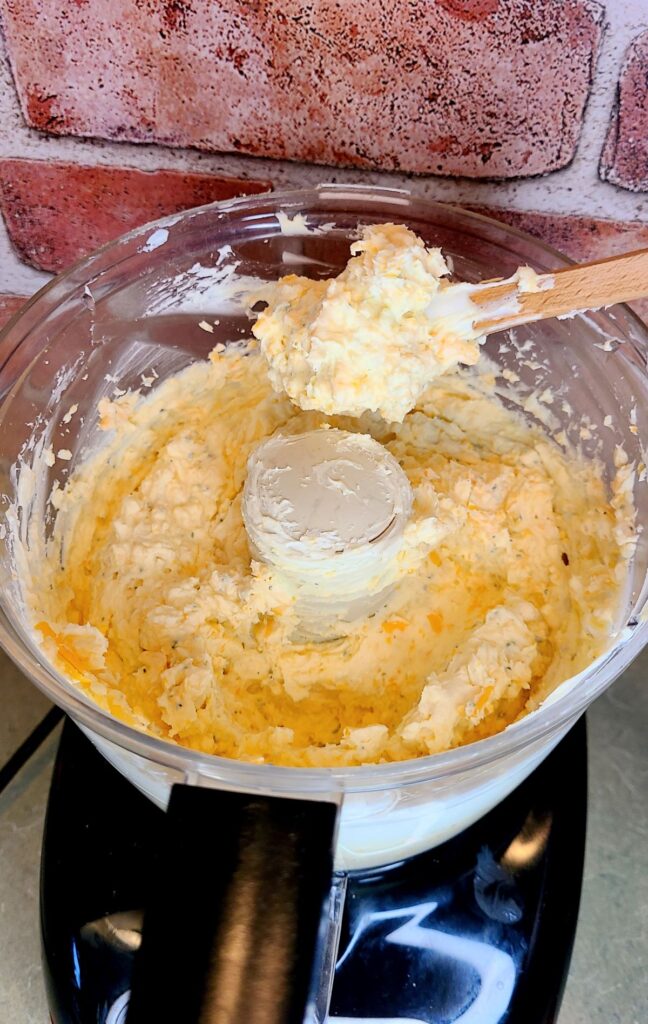 The cheese mixture of an easy low carb cheese ball with mascarpone and gouda in a food processor.