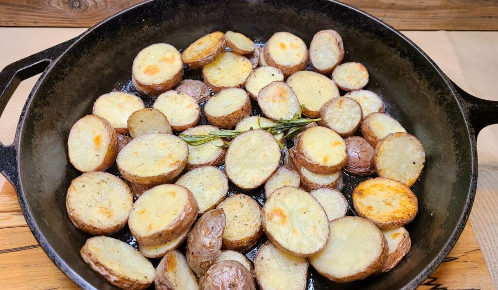  Easy Oven Roasted Potatoes With Rosemary Butter in a cast iron pan