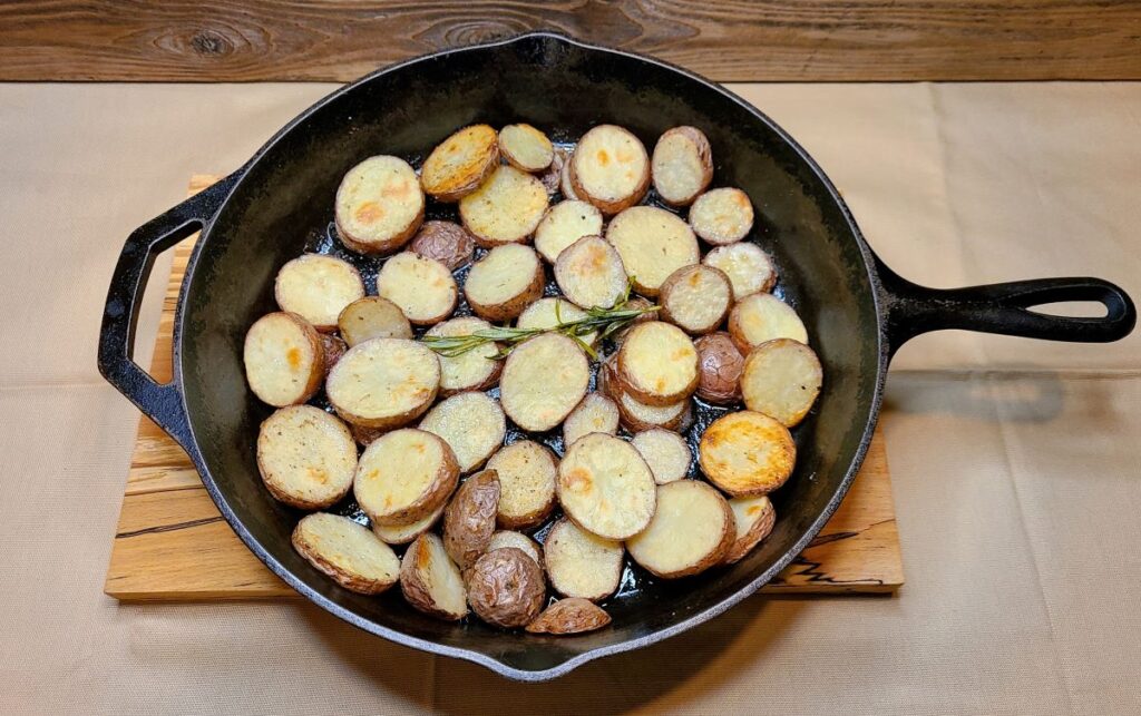 Cast iron skillet with  Easy Oven Roasted Potatoes With Rosemary Butter.