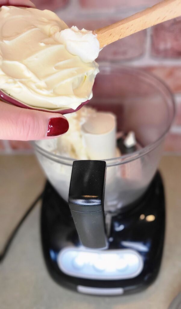 Scooping mascarpone cheese into a food processor