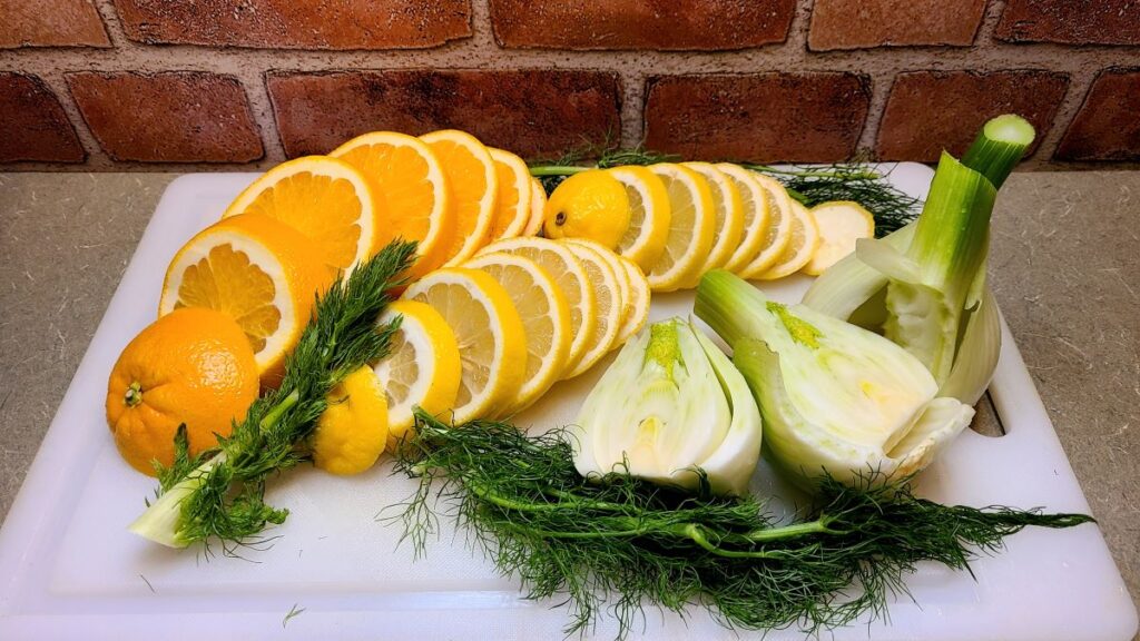 Cutting board with sliced citrus and fennel to stuff a terrific roasted French turkey with champagne and herbs.