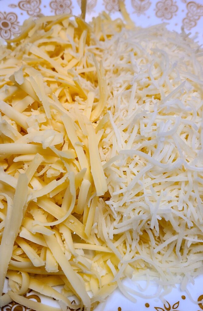 Up close of shredded cheeses. 