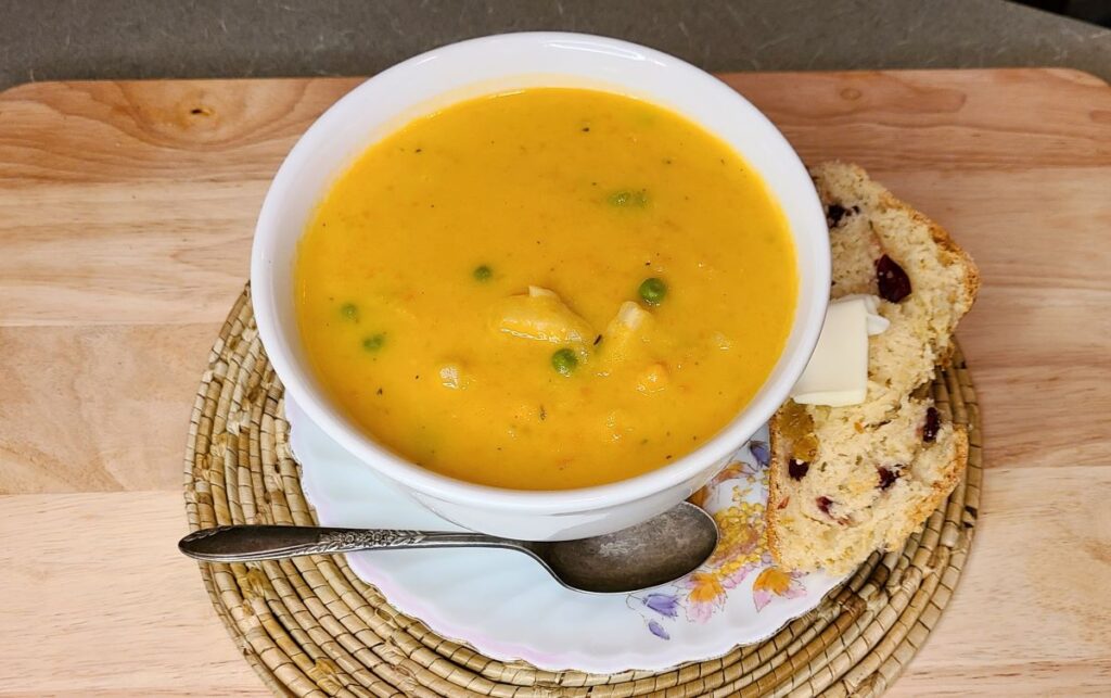 Easy homemade farmhouse Irish vegetable soup with rosemary in a white bowl with bread.