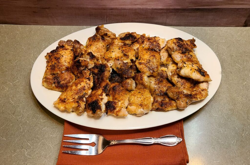 How To Perfectly Bake And Broil Boneless Chicken Thighs on a white platter