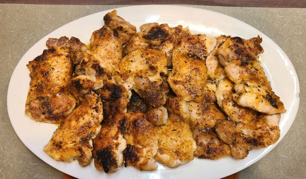 White plate of How To Perfectly Bake And Broil Boneless Chicken Thighs. 